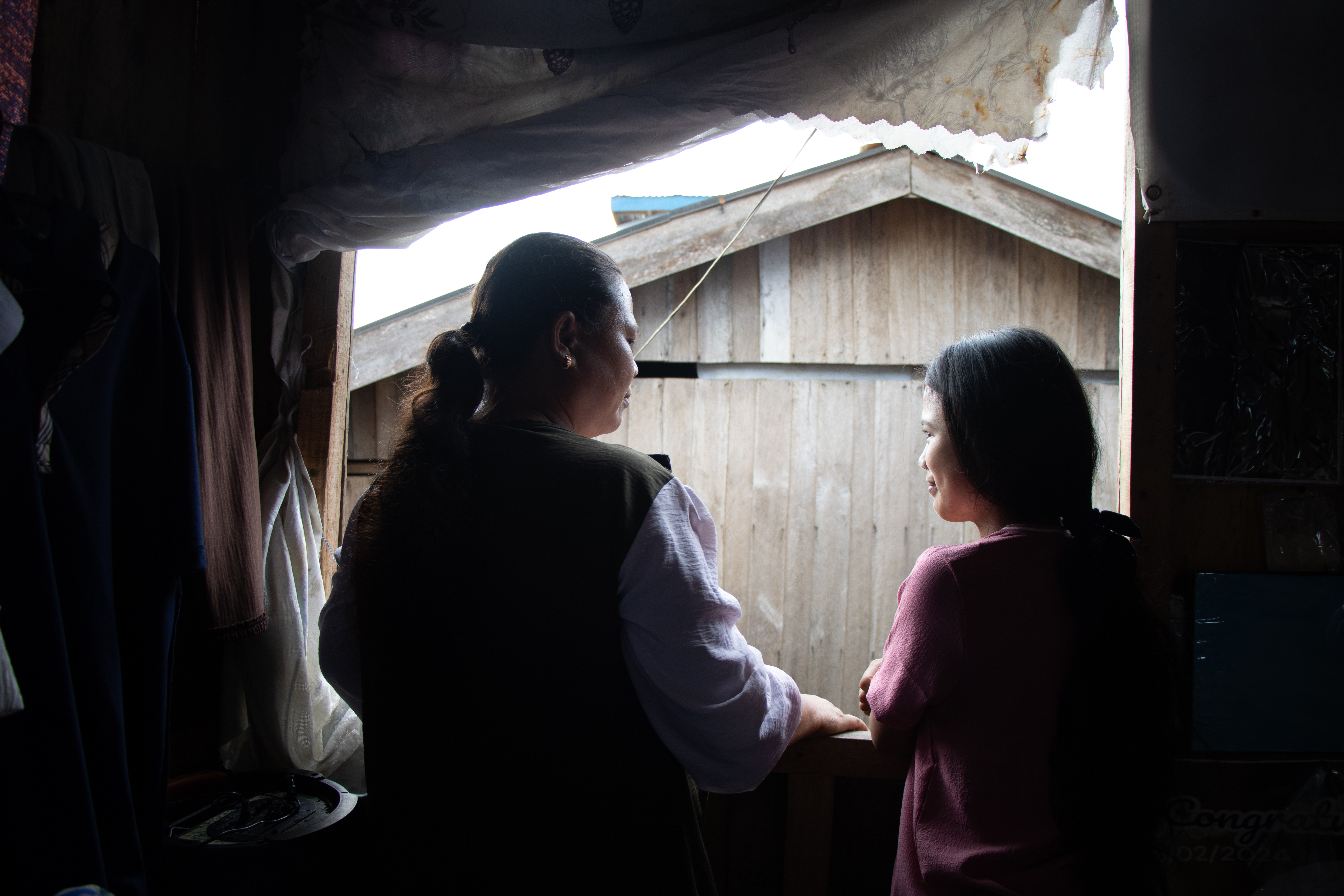 Dayang sits with her mother